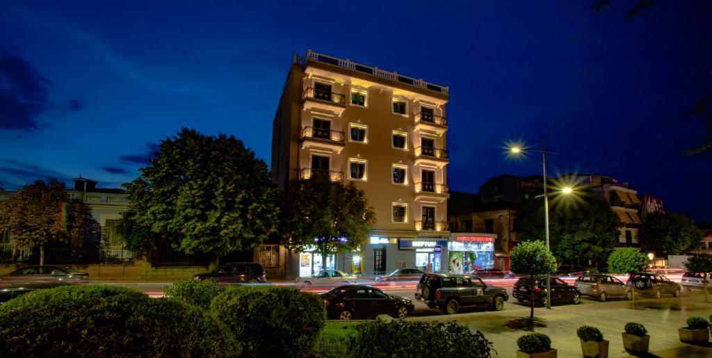 ein Gebäude mit nachts auf einem Parkplatz geparkt in der Unterkunft Christi's Hotel Borova in Korçë