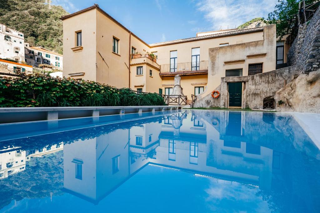 uma piscina de água em frente a um edifício em Amalfi Resort em Amalfi