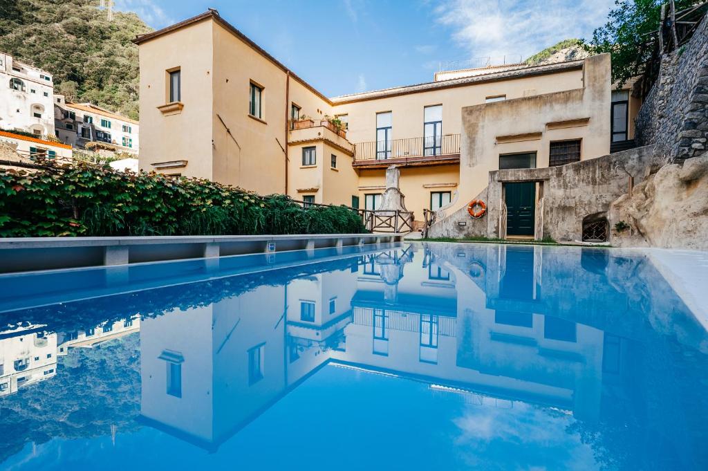 a pool of water in front of a building at Amalfi Resort in Amalfi