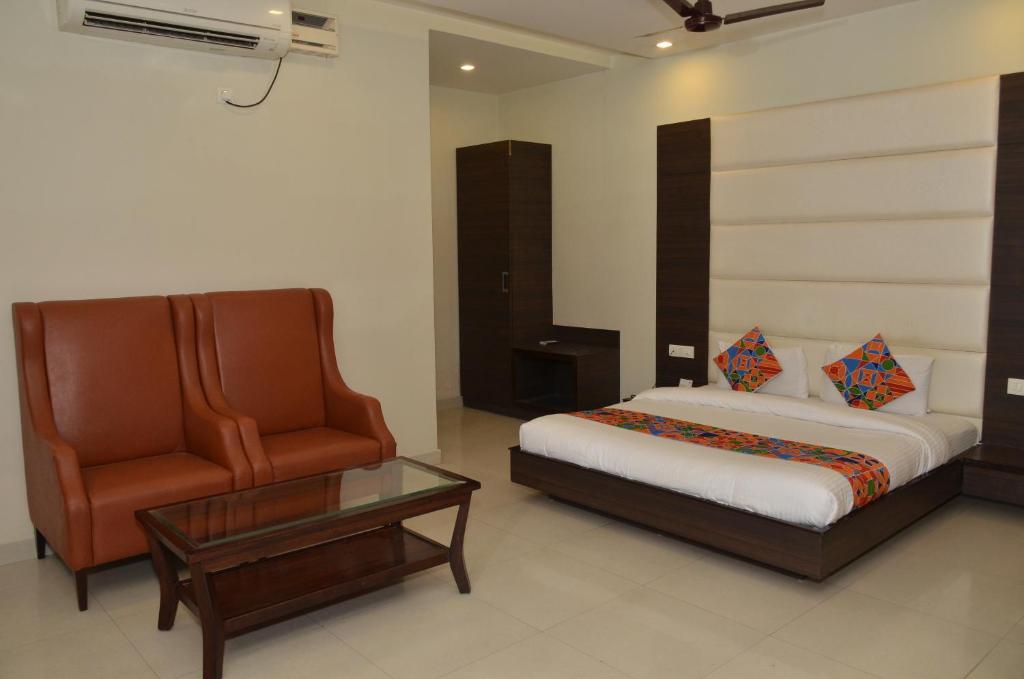 um quarto com uma cama, uma cadeira e uma mesa em Hotel KK Continental 50 Meter from Railway Station - Amritsar em Amritsar