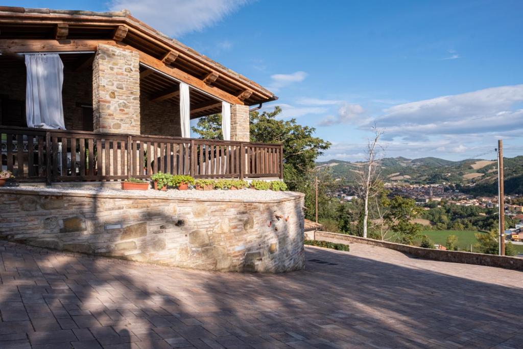 uma casa com uma parede de pedra e uma varanda em B&B da Vi.Vì em Urbania