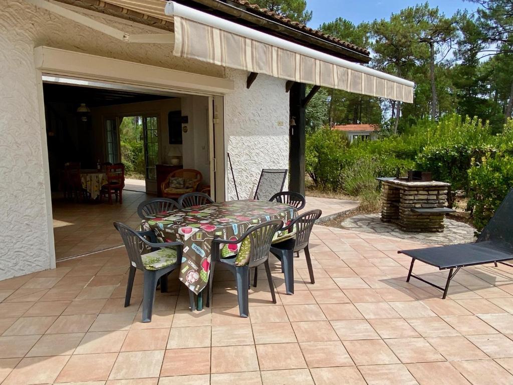 a table and chairs sitting on a patio at Cottage with a big idyllic garden at the lake in Lacanau