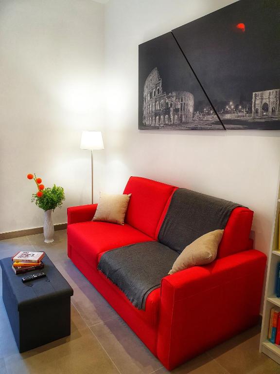 a red couch sitting in a living room at Domvs Romae Apartment in Rome