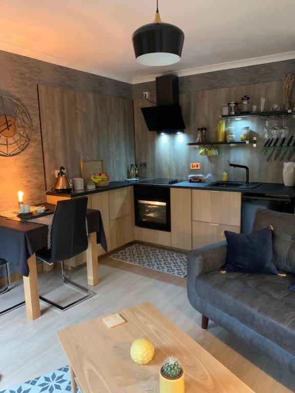 a living room with a couch and a kitchen at Aaron's Bothy in Portree