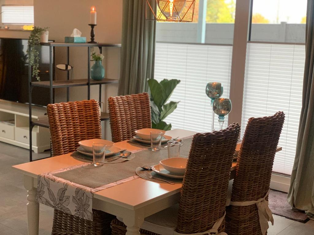 een eettafel met stoelen en een tafel en een stoel bij Ferienwohnung Gartenstadt in Flensburg