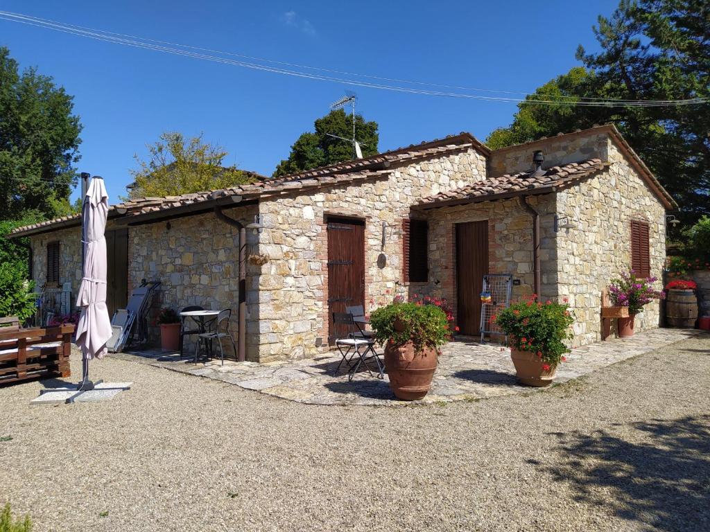 ein Steinhaus mit zwei Topfpflanzen davor in der Unterkunft Sandra House in Castellina in Chianti