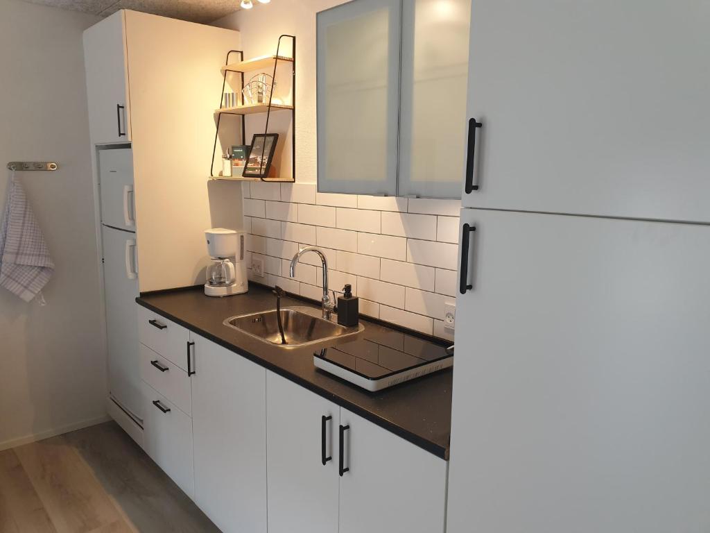 a kitchen with white cabinets and a sink at Emda Country living close to Legoland in Billund