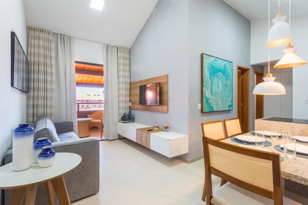 ein Wohnzimmer mit einem Tisch und einem Esszimmer in der Unterkunft Flat Extra Oka Beach Residence Muro Alto in Porto De Galinhas