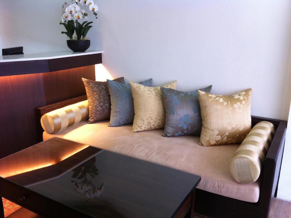 un divano con dei cuscini in una stanza di Smile Society a Bangkok