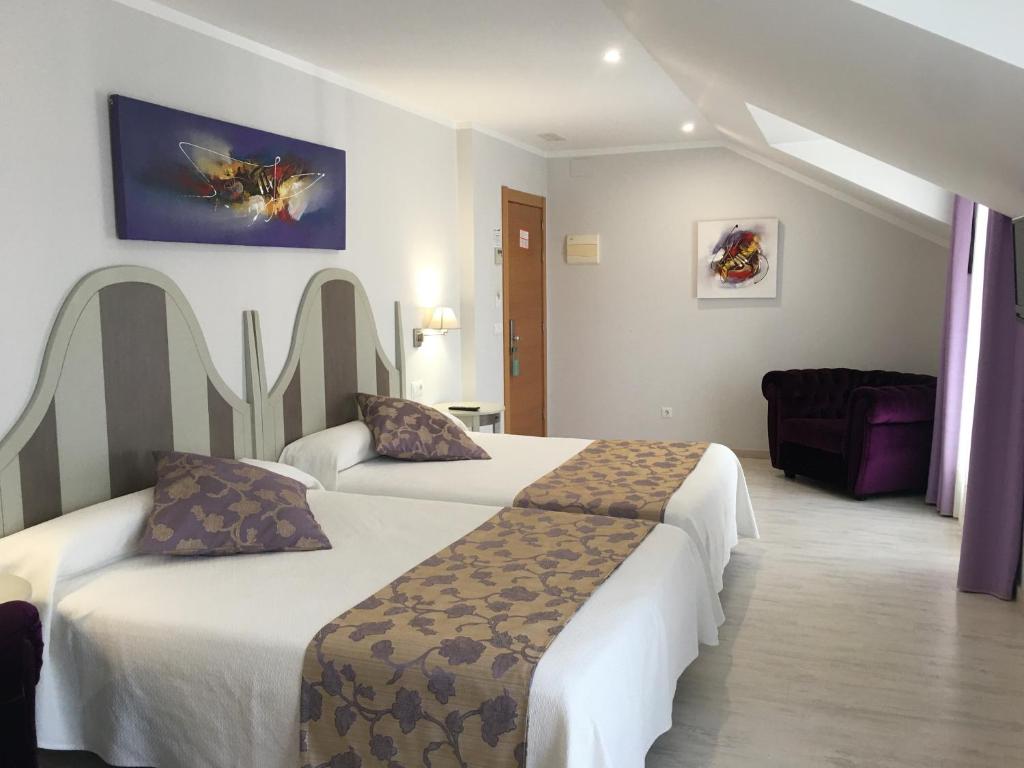 カベソン・デ・ラ・サルにあるHotel Valle de Cabezónのベッド2台とソファが備わるホテルルームです。