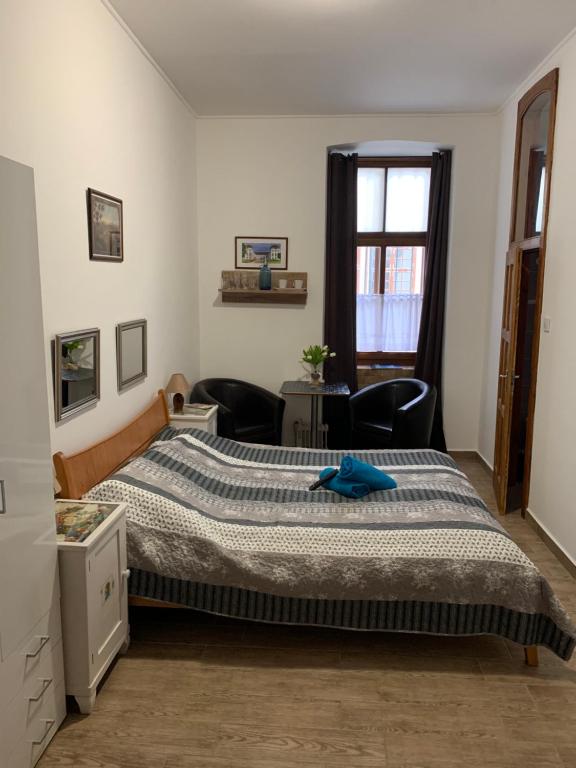 a bedroom with a large bed and a window at Anna Apartman in Pápa