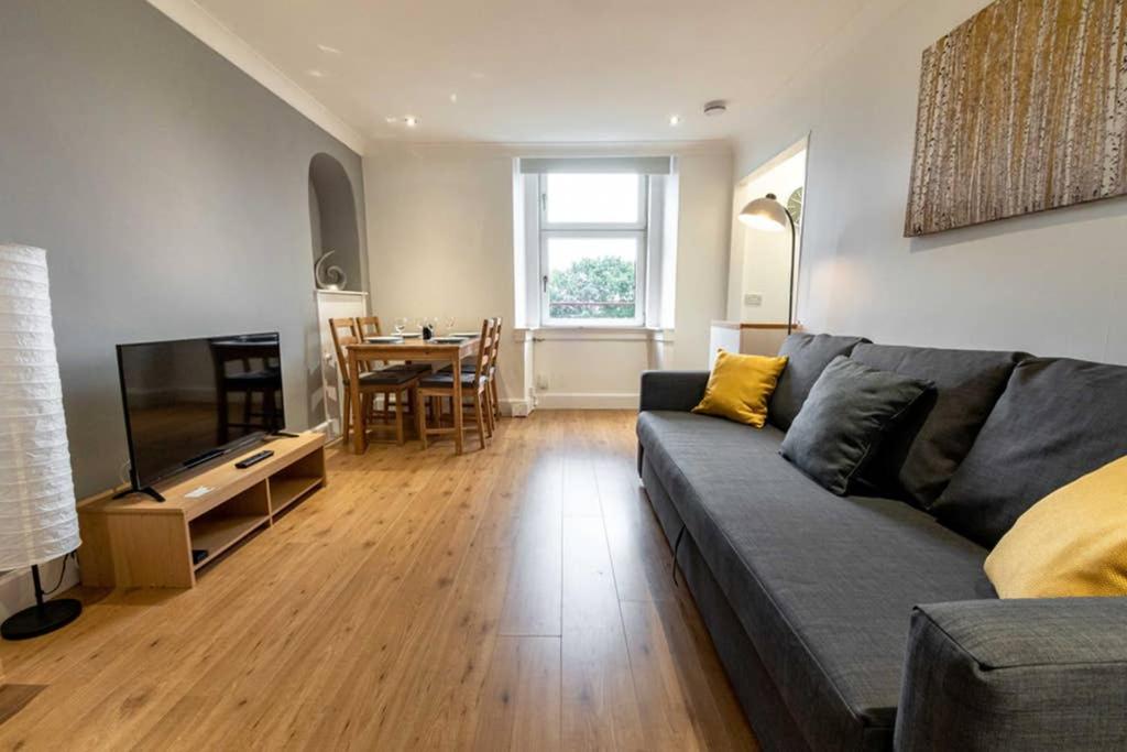 a living room with a couch and a table at ☆Bright Apartment, Near University + City Centre☆ in Dundee