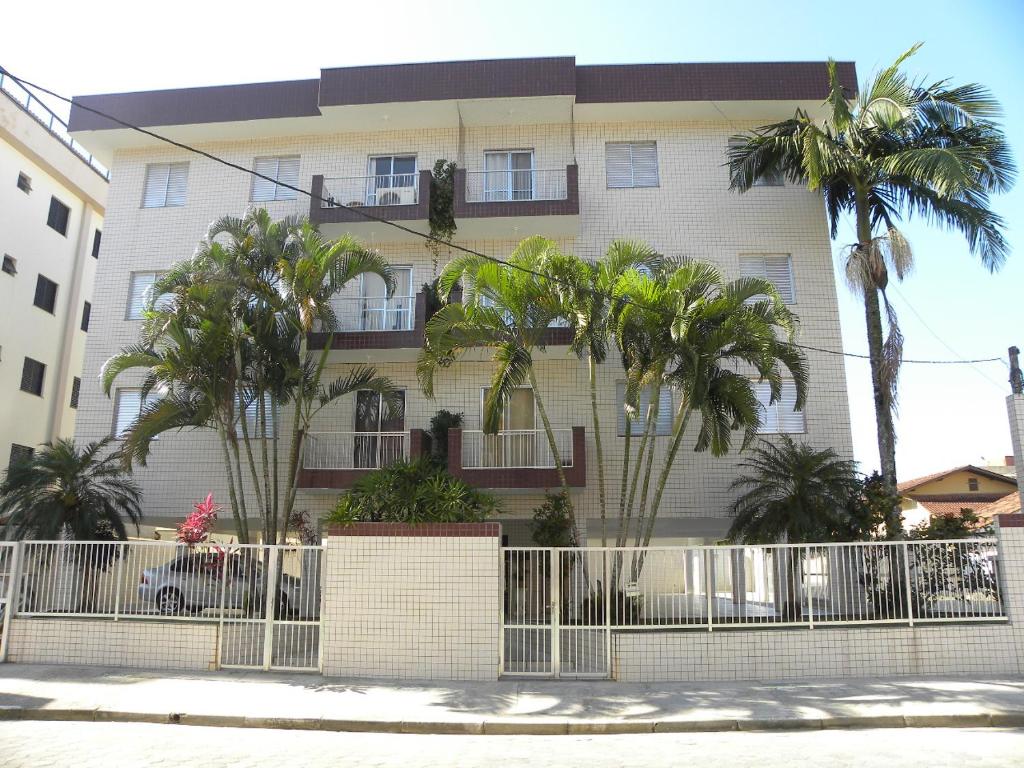 ein Gebäude mit Palmen davor in der Unterkunft Apartamento 3 quartos de cobertura na Praia Grande em Ubatuba in Ubatuba