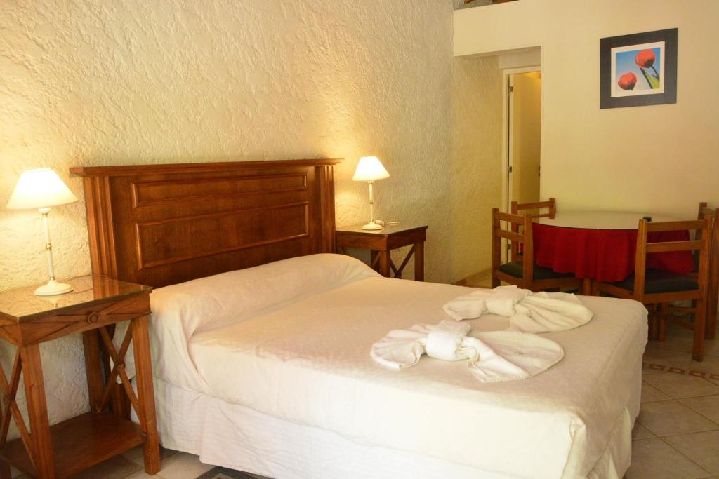 um quarto de hotel com uma cama com toalhas em Sesma Excelencia en Cabañas em São Rafael