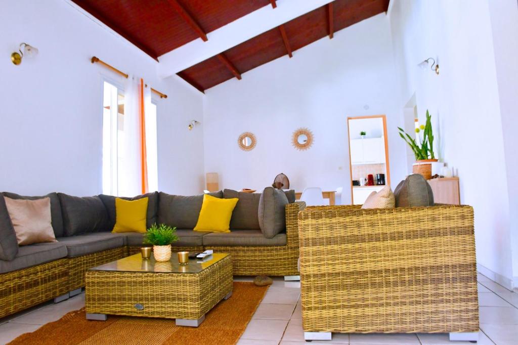 a living room with two couches and a table at Villa Sunrise in Deshaies