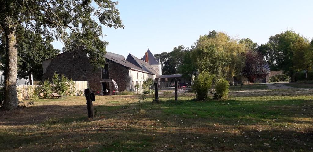 una casa in un campo con un albero e un edificio di au fabuleux festin a La Possonnière