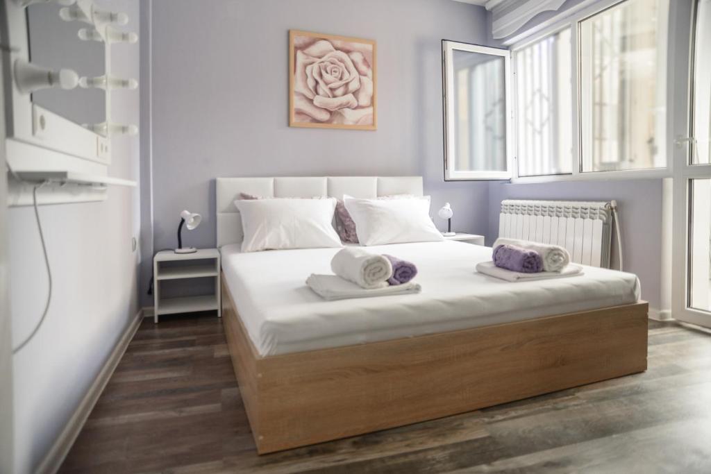 a bedroom with a bed with two towels on it at Apartment MARTINI in Burgas City