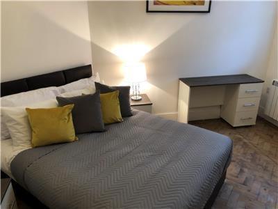 a bedroom with a bed with yellow pillows and a desk at King Edward House Flat 1 in Hull
