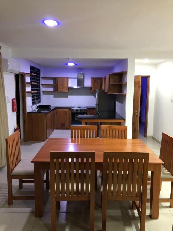 a kitchen and dining room with a wooden table and chairs at Kolibri Holiday Apartments in Victoria