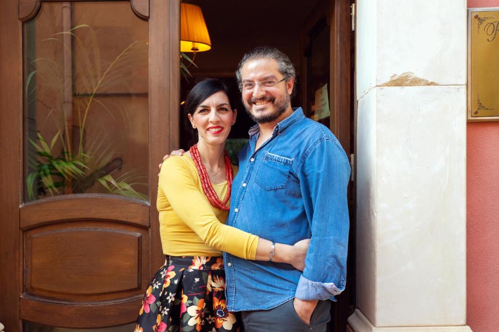 a man and a woman standing in front of a door at Relais Briuccia e Ristorante Capitolo Primo in Montallegro