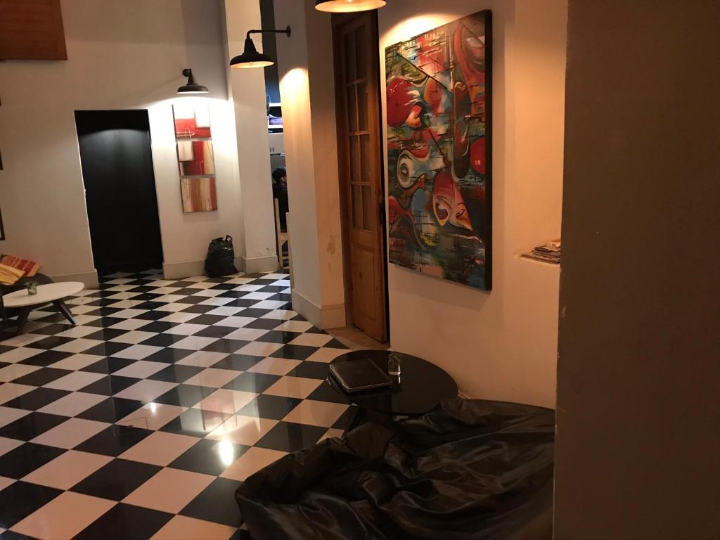 una habitación con suelo a cuadros y una pintura en la pared en AHIVÁ Espacio Temporal, en Montevideo