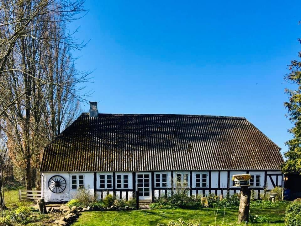 Biały dom z zegarem na boku w obiekcie Sivagerhuset Holiday-Home w mieście Bogense