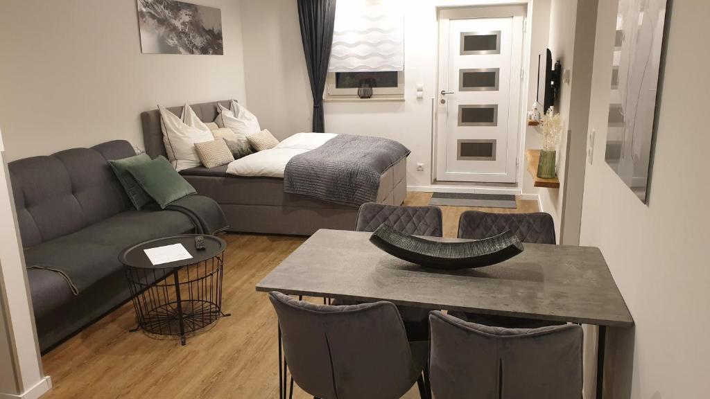 een woonkamer met een bank en een tafel met stoelen bij Apartment Airport Cologne in Keulen