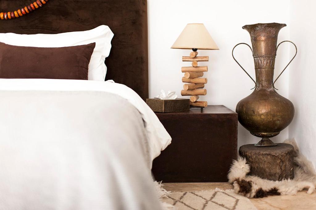 a bedroom with a bed and a table with a lamp at Room in BB - Suite Atlas in luxurious Riad - Marrakech in Marrakesh