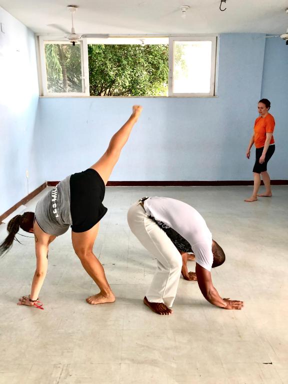 two women performing a yoga pose in a room at Nomads Hostel Multicultural & Coworking in Salvador