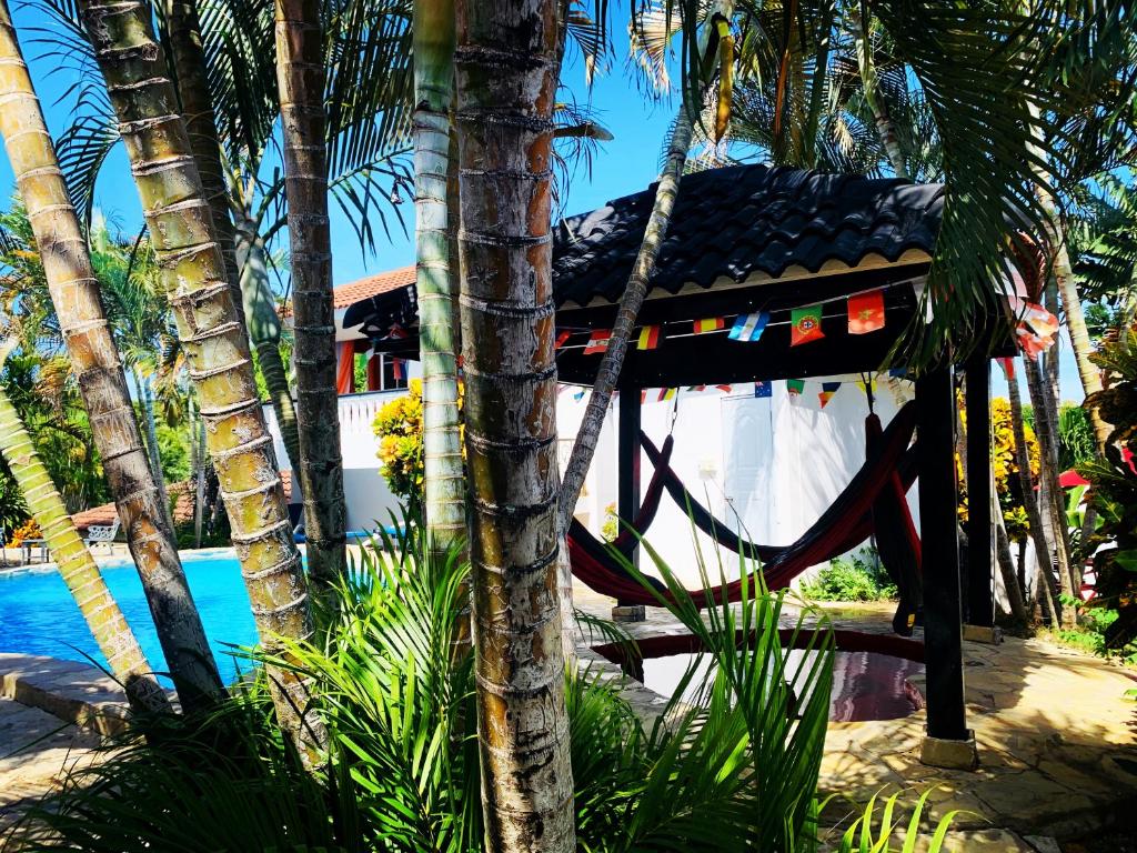a resort with a hammock next to a pool at HappiCasaRD & Holistic House in Sosúa