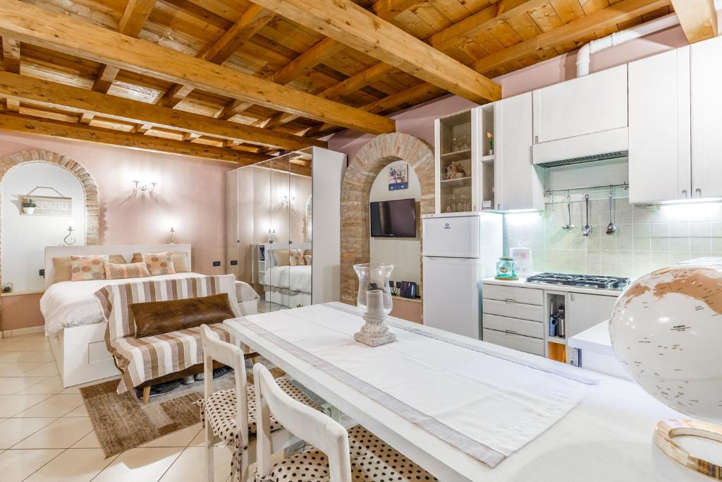 eine Küche und ein Wohnzimmer mit einem Tisch und Stühlen in der Unterkunft Nell'antico ghetto ebraico in Ferrara
