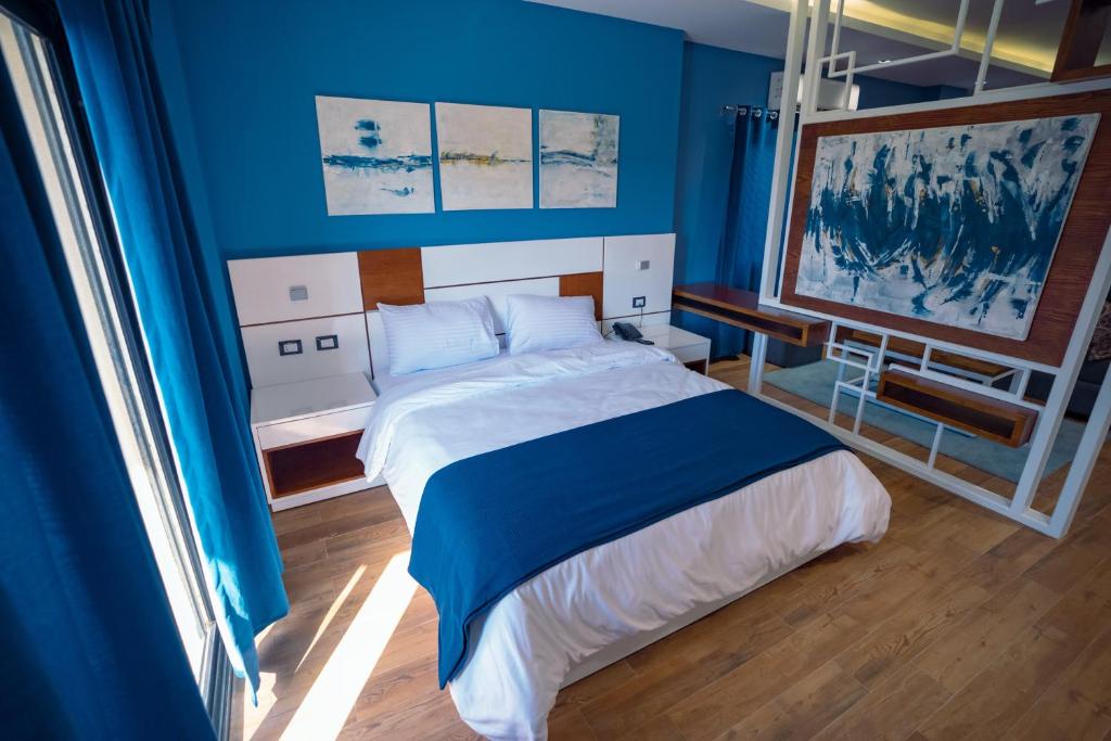 a bedroom with a large bed with blue walls at Travelholic Residence New Cairo in Cairo