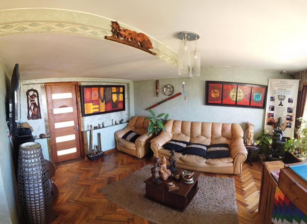 sala de estar con sofá y mesa en Hostal Tunquelen, en Valparaíso