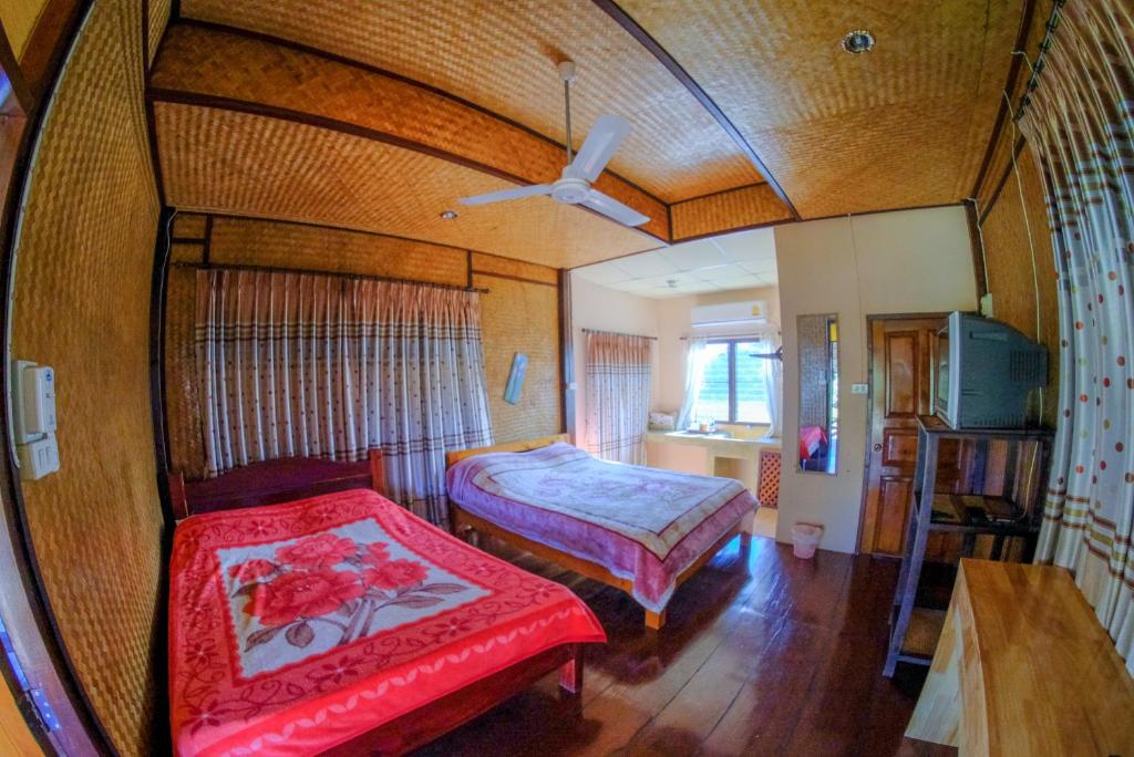 Pai Tewdoi Garden ปาย ทิวดอย การ์เด้น في باي: غرفة نوم بسريرين ومروحة سقف