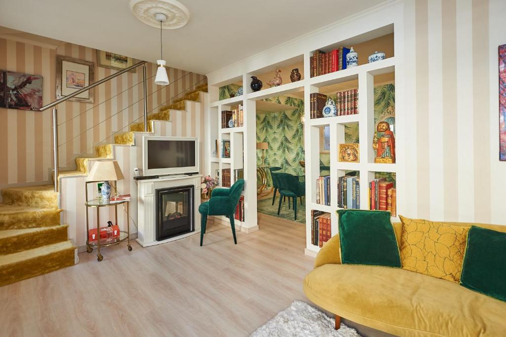 エストリルにある2 bedrooms appartement at Estoril 500 m away from the beach with enclosed garden and wifiのリビングルーム(黄色のソファ、暖炉付)