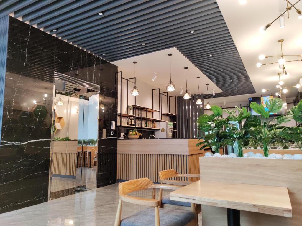 un restaurante con mesa, sillas y plantas en Hong Hao Hostel and Motorbikes, en Ha Giang