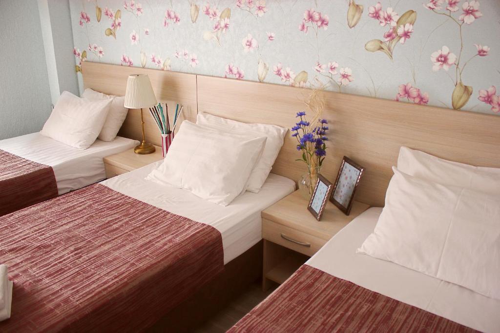 クラスノダールにあるКвартиры р-н ТЦ Красная площадьのベッド2台が備わる客室で、壁に花が飾られています。