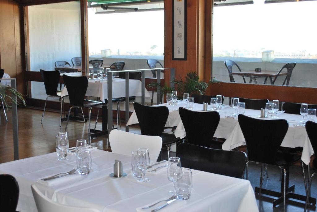 a dining room with white tables and chairs at Hotel le Corbusier in Marseille