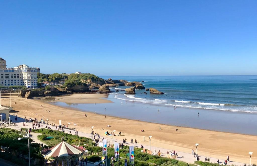 una playa con un grupo de personas y el océano en L'océan à perte de vue, la grande plage à vos pieds en Biarritz