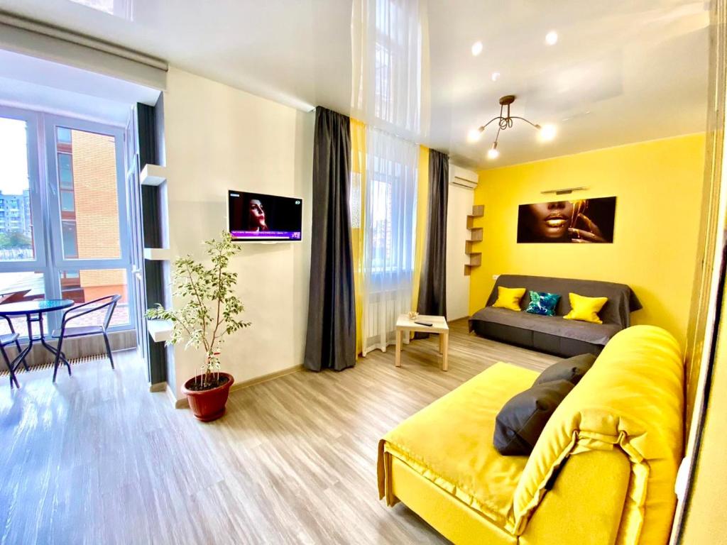 een gele woonkamer met een bank en een tafel bij Grey&Yellow на Коцюбинського in Vinnytsya