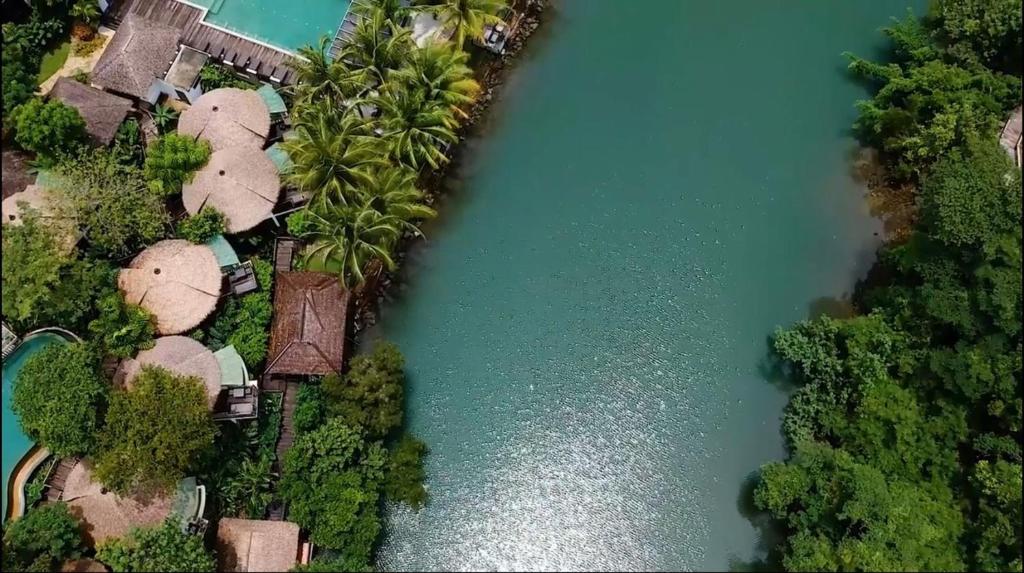 eine Luftansicht auf einen Fluss mit Gebäuden und Bäumen in der Unterkunft Aana Resort & Spa in Ko Chang
