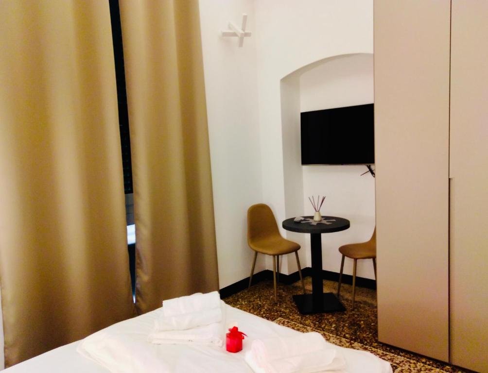 a hotel room with a bed and a small table at Palazzo San Giorgio ( S ) in Genova