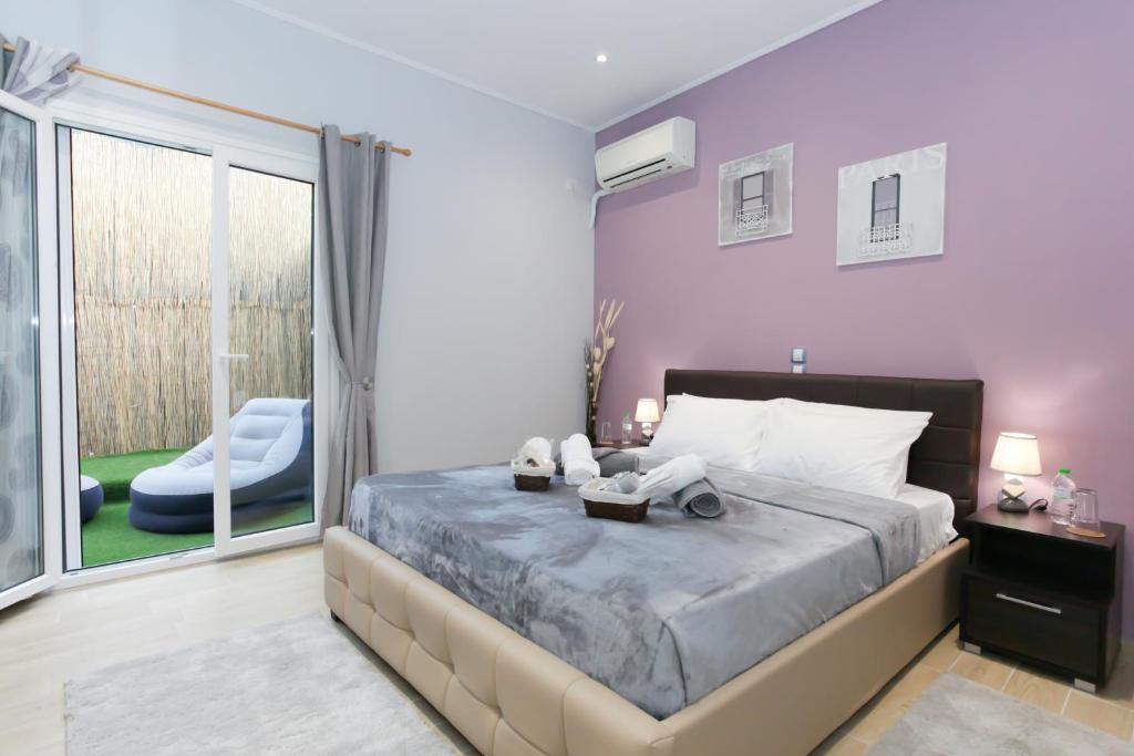ein Schlafzimmer mit einem großen Bett mit lila Wänden in der Unterkunft Athens OwlCity in Athen