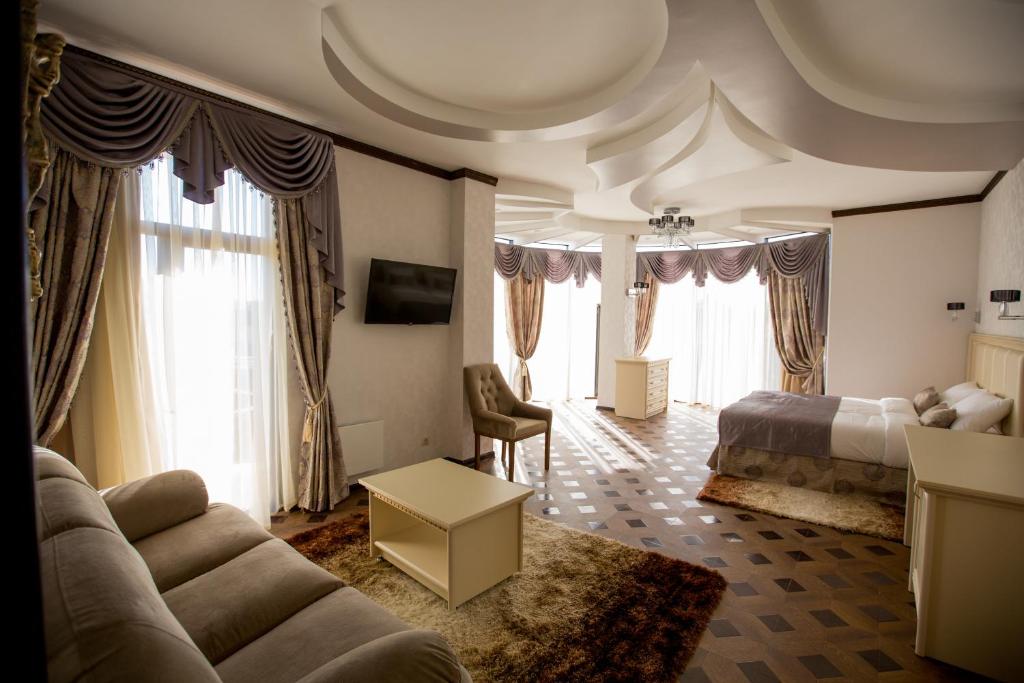 a living room with a bed and a couch in a room at Shine House Hotel in Adler