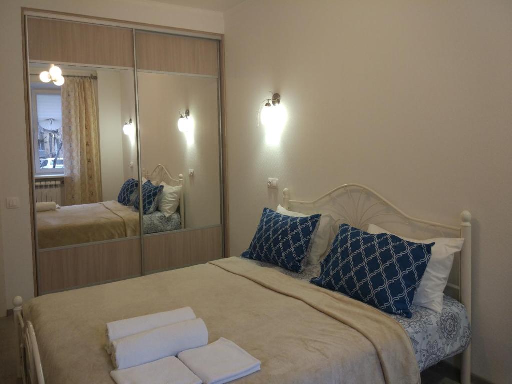 a bedroom with a bed and a large mirror at Apartment на Полковой в центре in Omsk