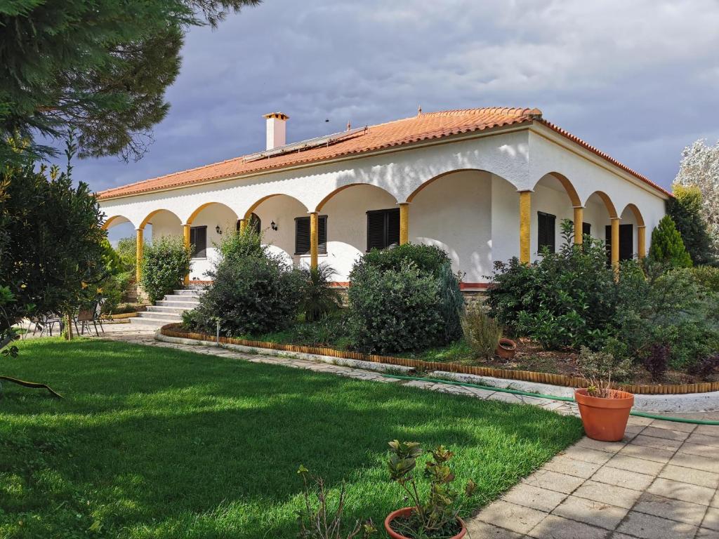 una gran casa blanca con un patio verde en Casa das Portas, en Azinhaga
