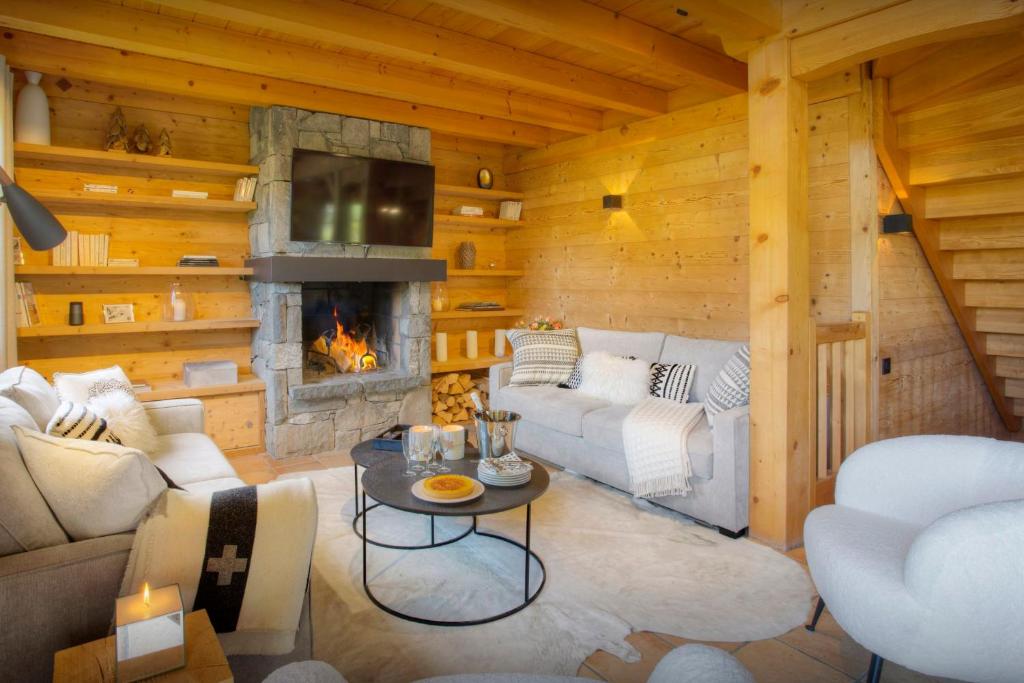 ein Wohnzimmer mit einem Sofa und einem Kamin in der Unterkunft Chalet Cosyneige - OVO Network in La Clusaz