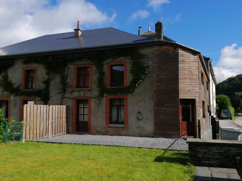 a brick house with a fence in front of it at l'oiseau d'eau in Bouillon