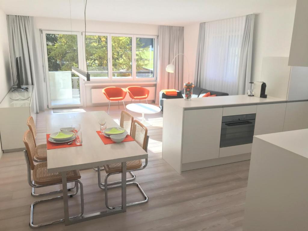 kuchnia i salon ze stołem i krzesłami w obiekcie Ginseng w Davos