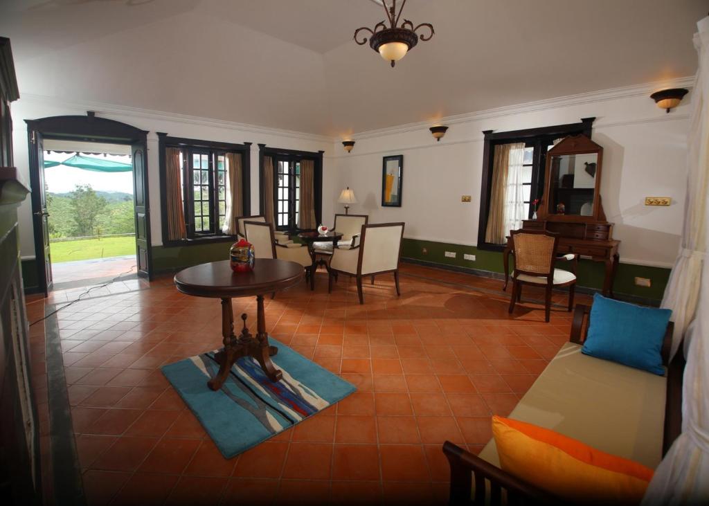 a living room with a couch and a table at Parisons Plantation Experiences by Abad in Mananthavady